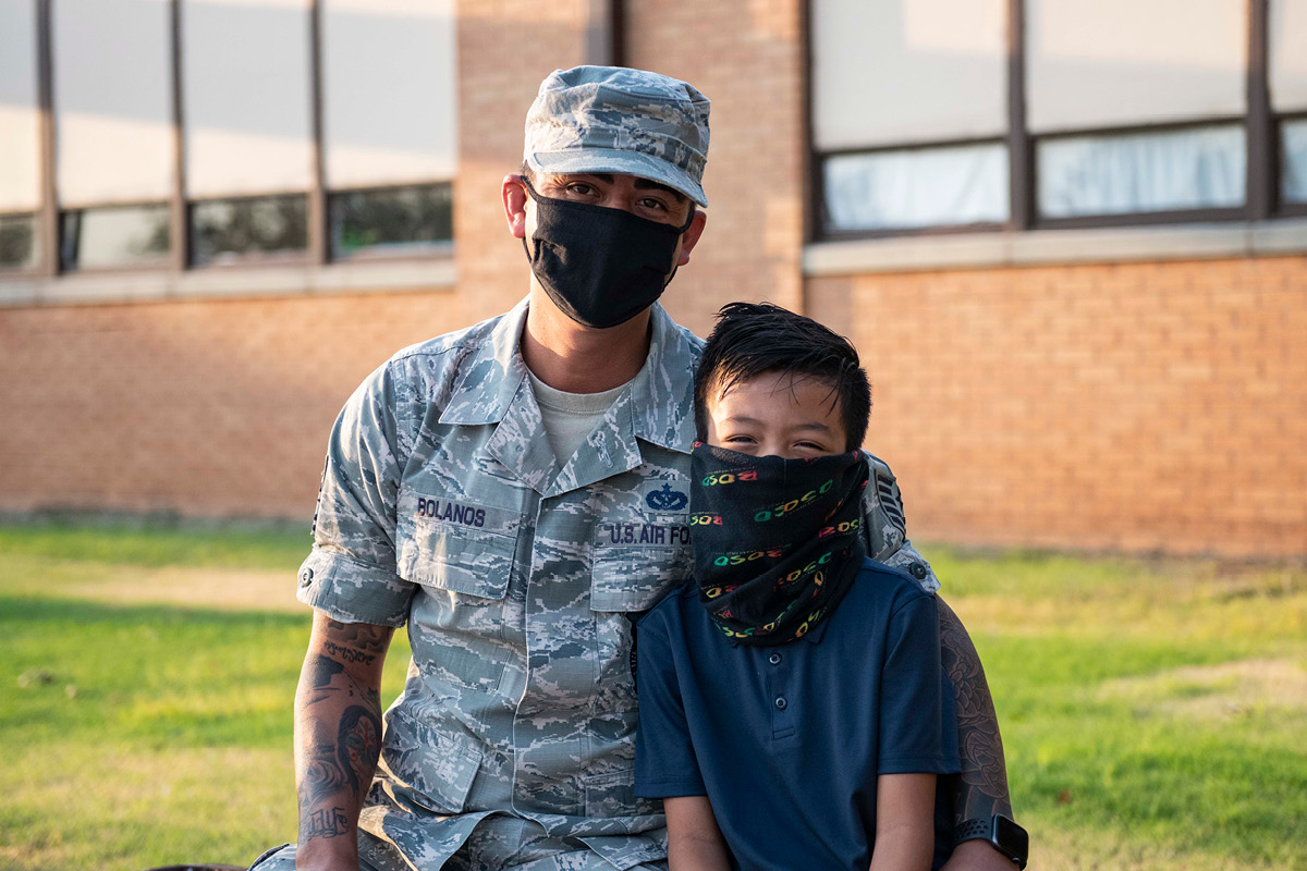 U.S. Air Force Tech. Sgt. Francisco Bolanos and his son sit in front of Rivers Elementary School on August 17, 2020 at Altus Air Force Base, Oklahoma. U.S. Air Force photo by Senior Airman Breanna Klemm
