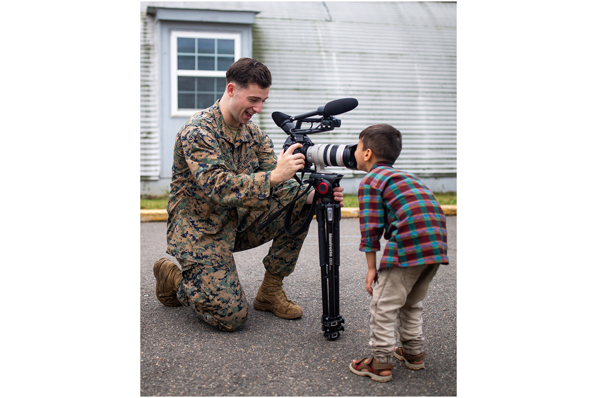 U.S. Marine Corps Cpl. Michael Slavin, videographer with Marine Corps Base Quantico, Virginia, interacts with an Afghan child at Upshur Village in Quantico in Sept. 2021. Marine Corps photo by Tia Dufour