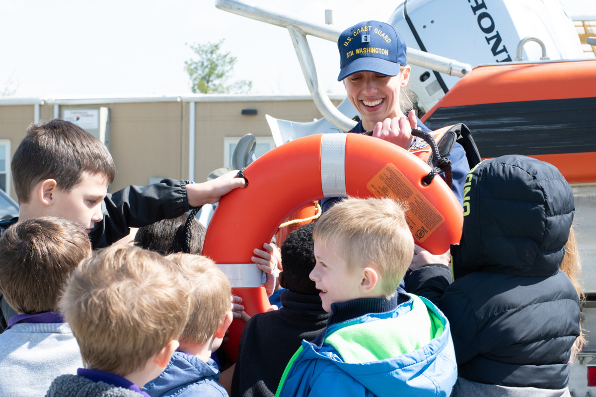 Lt. Cate Giguere, Station Washington Commanding Officer, shows off a life ring to students of LEARN DC at Joint Base Anacostia-Bolling in April 2022. U.S. Coast Guard Photo by Patrick Ferraris